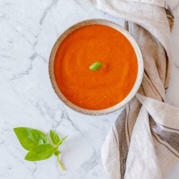 Tomato Soup with Basil, sitting on a marble benchtop.