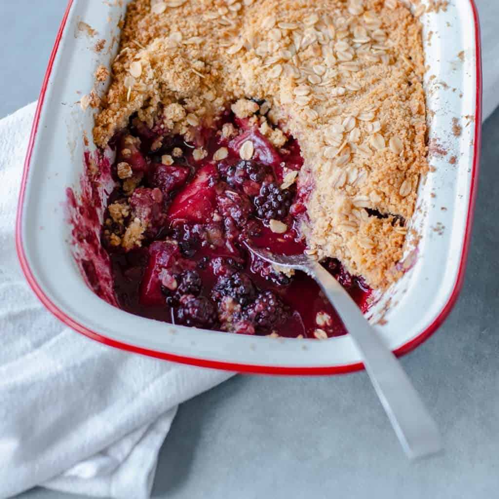 Close up image of blackberry and apple crumble.